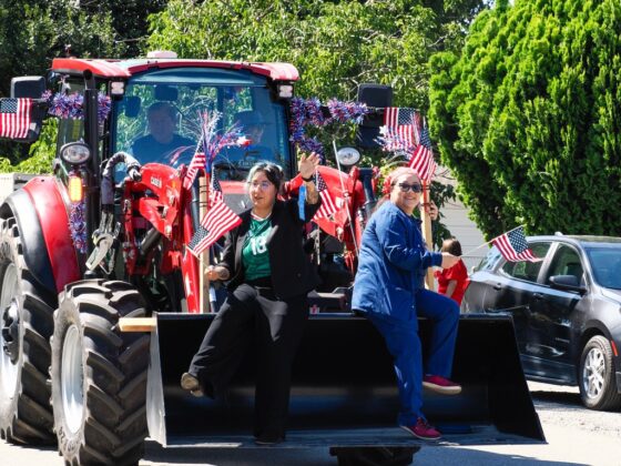 Participants ride on a decorated tractor and wave to spectators during the Grimes 175th Anniversary and Fourth of July parade on July 4. Photo by Chris Pedigo.