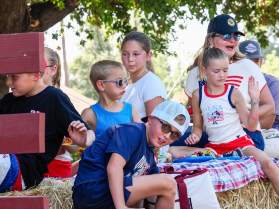 Colusa County Supervisor Daurice Kalfsbeek-Smith rides with children on a parade float during the Grimes 175th Anniversary and Fourth of July parade on July 4. Photo by Chris Pedigo.
