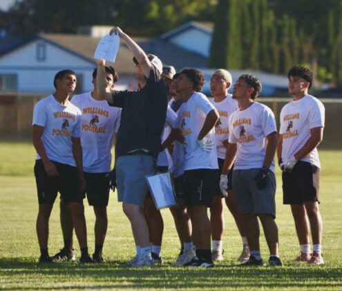 Yellowjacket coach Forrest Bateman outlines a play for his team during a 7 v 7 competition on July 1.